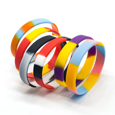 A set of silicone bangles with multicolor tie-dye patterns, including shades of yellow, blue, red, purple, orange, black, and white, arranged on a clean white background.