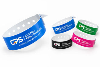Five customizable Vinyl Wristbands from GPS Custom Print Supplies in blue, green, black, and pink, displayed on a clean white background.