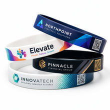 Four custom printed silicone wristbands stacked on a white background, each featuring a different corporate design with logos, text, and QR codes.