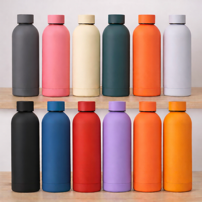Row of colorful water bottles on a wooden surface with a white background