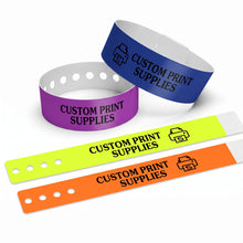 Four customizable wristbands in blue, purple, neon yellow, and orange, all printed with the text 'CUSTOM PRINT SUPPLIES' and a printer icon, displayed on a clean white background.